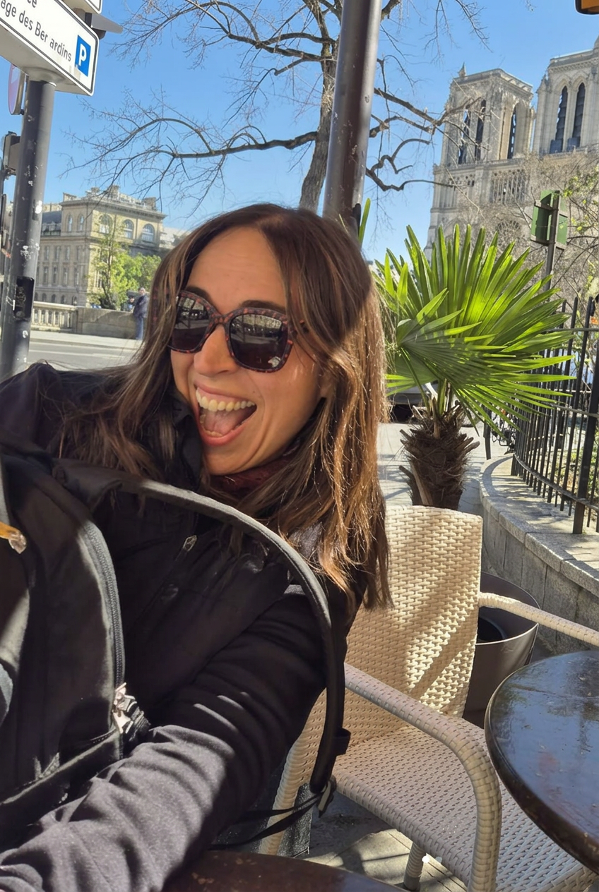 Leslie smiling outside a Paris café near Notre-Dame